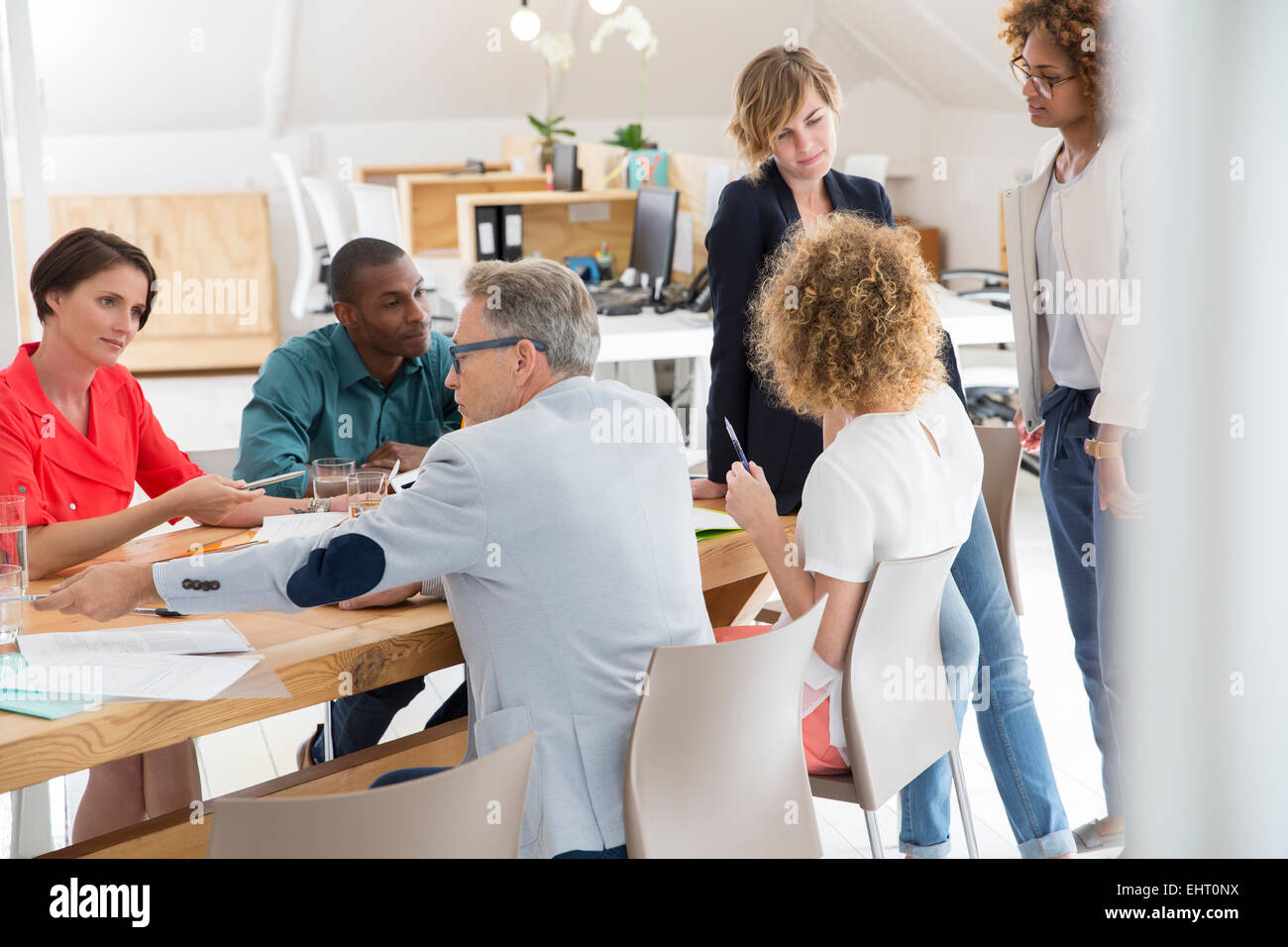 Gruppo di lavoratori ufficio parlando a scrivania Foto Stock