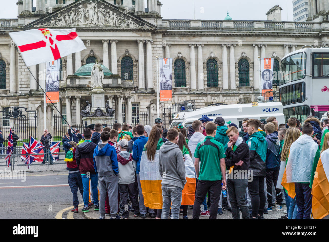 Gruppi rivali repubblicani drappeggiati in irlandese Tricolors e sindacalisti sventolando bandiere Unione affacciate nella parte anteriore del Municipio. Foto Stock