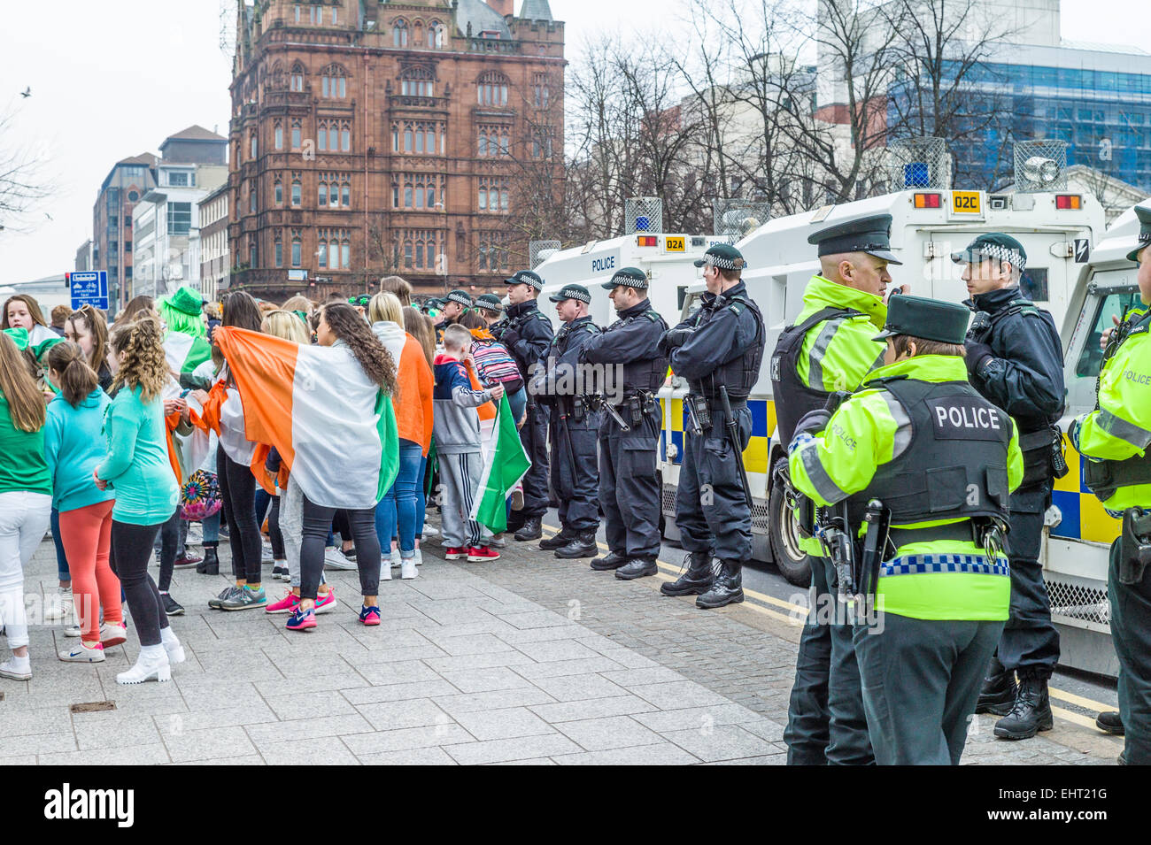 Gruppi rivali repubblicani drappeggiati in irlandese Tricolors e sindacalisti sventolando bandiere Unione affacciate nella parte anteriore del Municipio. Foto Stock