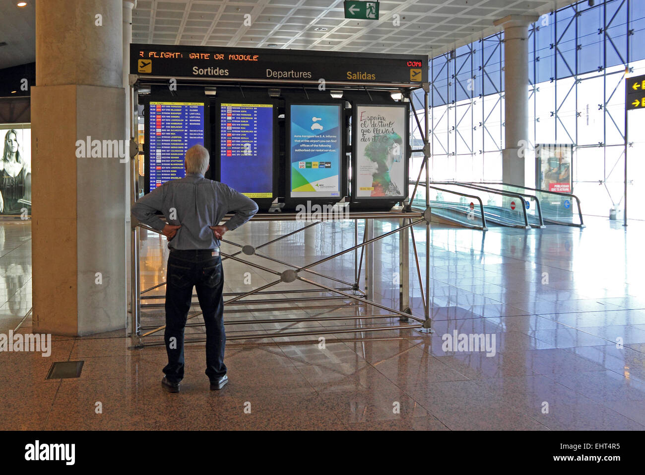 Uomo maturo guardando le partenze pensione all'aeroporto El Prat di Barcellona Foto Stock