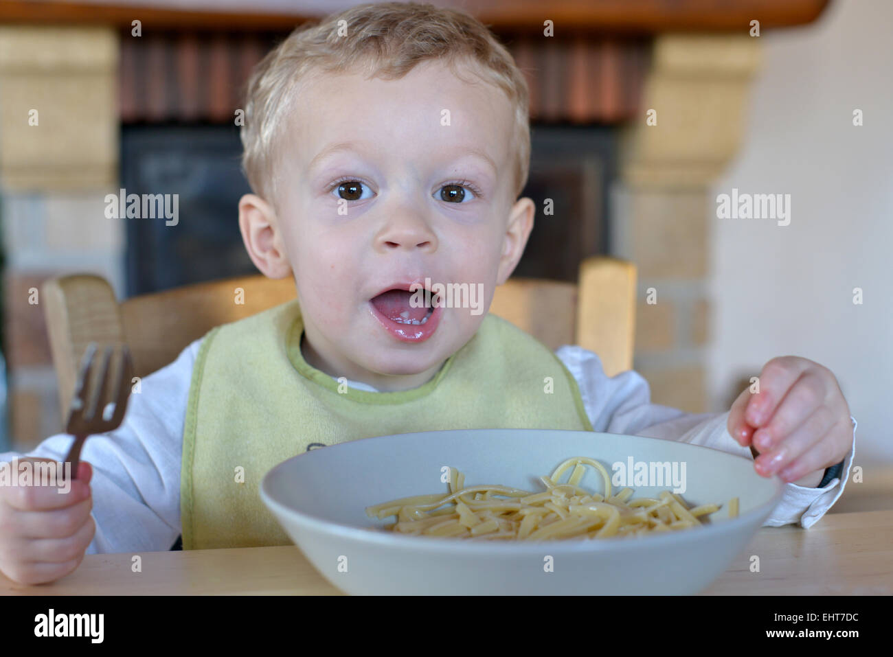 Baby mangia la pasta seduti a un tavolo Foto Stock