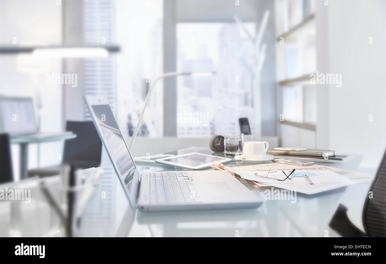 Tabella disordinato nella sala conferenze di un ufficio moderno con il computer portatile Foto Stock