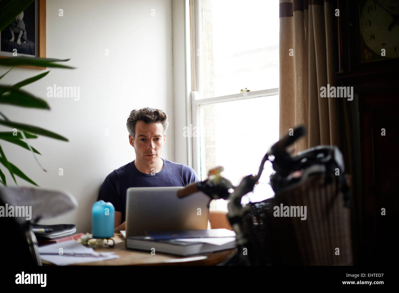 Uomo al lavoro su laptop a casa Foto Stock