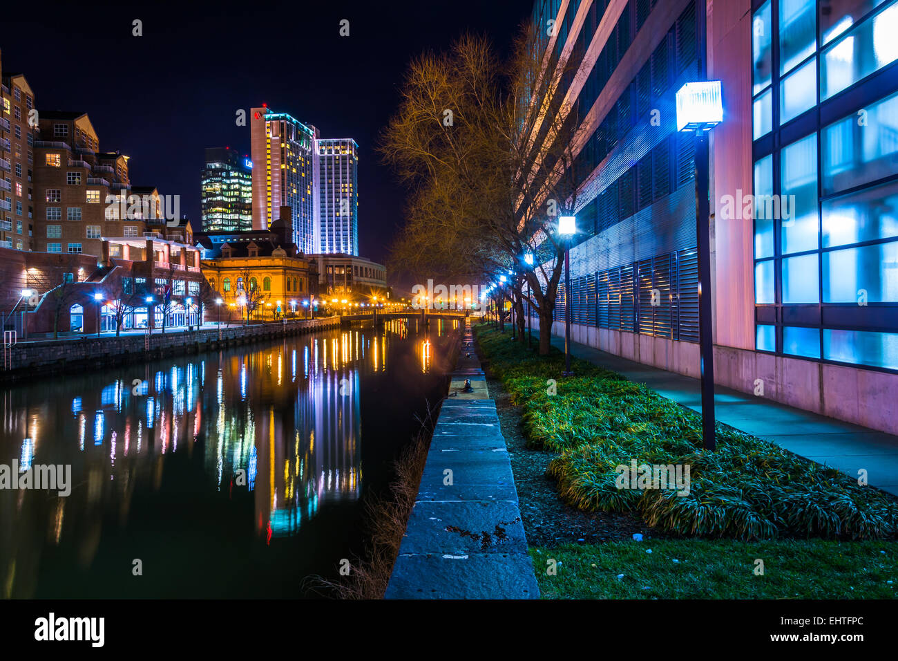 Gli edifici che riflettono in acqua di notte nel Porto Interno di Baltimore, Maryland. Foto Stock