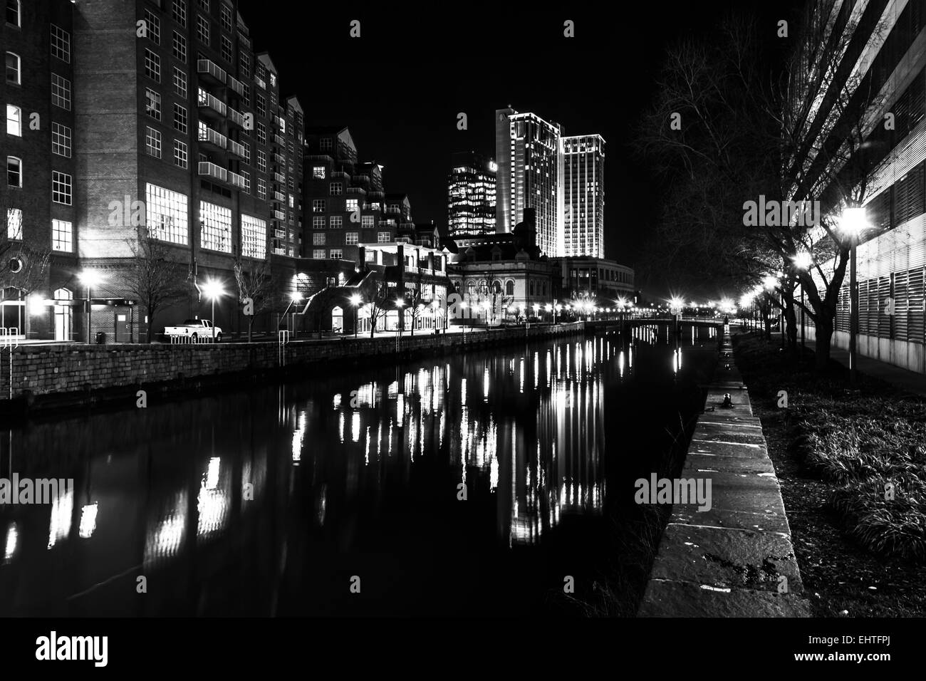 Gli edifici che riflettono in acqua di notte nel Porto Interno di Baltimore, Maryland. Foto Stock