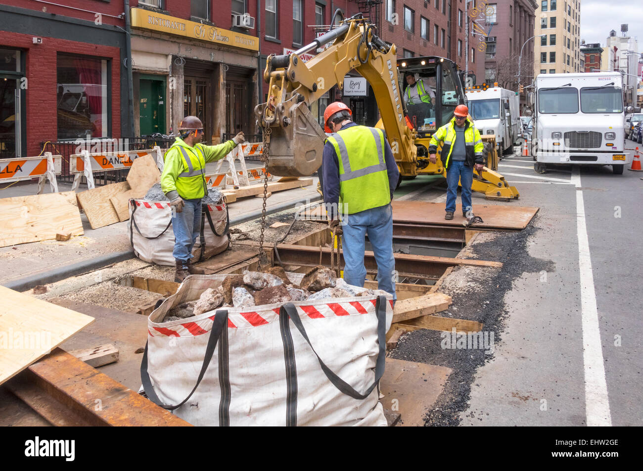 Lavoratori la rimozione di detriti da rottura di un tratto della metropolitana di New York City di infrastruttura su Grand Street in Little Italy Foto Stock