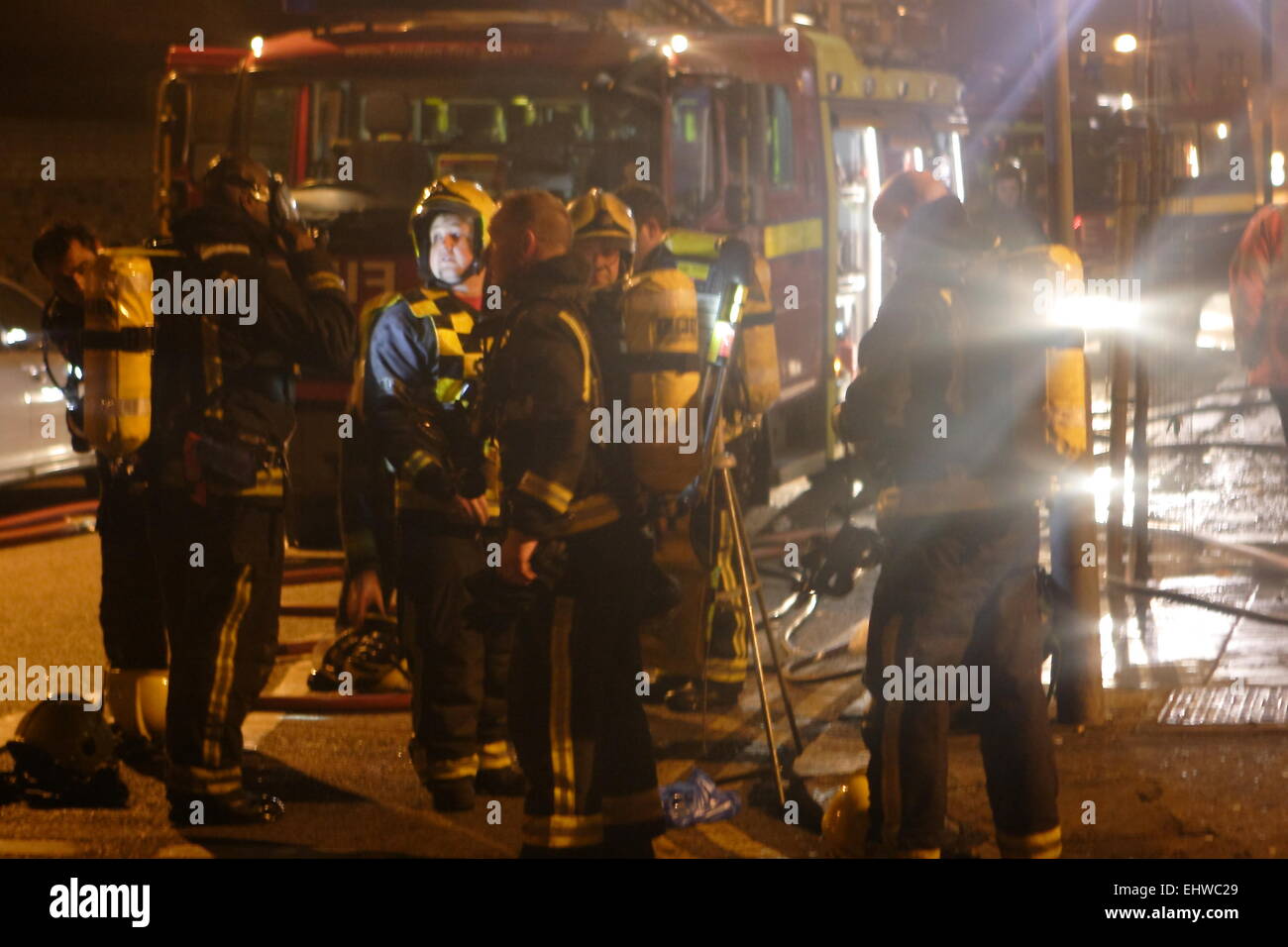 Ilford, Londra, Regno Unito. Mercoledì 18 marzo 2015. 11 salvato dal fuoco in appartamenti al di sopra di un negozio di Ilford. Sei motori Fire provenienti da tutta la zona est di Londra affrontato un incendio in un blocco di appartamenti a Ilford questa mattina. Londra i Vigili del Fuoco hanno riferito che sei adulti e cinque bambini tra cui un bambino sono stati soccorsi dai vigili del fuoco per mezzo di scale. È riportato che l'incendio scoppiato in un negozio sotto gli appartamenti. Foto Stock