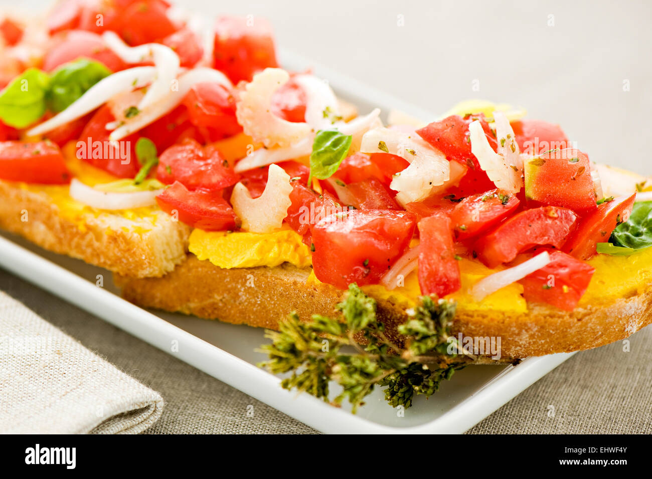 Bruschetta mediterranea o dito spuntini serviti come antipasti con fresco a dadini di pomodoro piccante e cipolla su baguette affettata Foto Stock