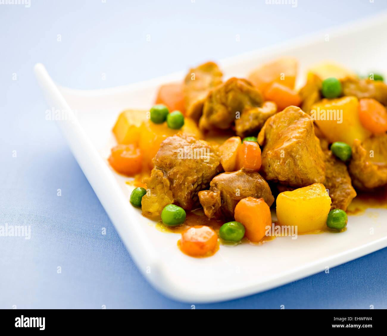 Vista ravvicinata di una dose di sano stufato di manzo con verdure incluse le patate, piselli e le carote su un piatto da portata Foto Stock