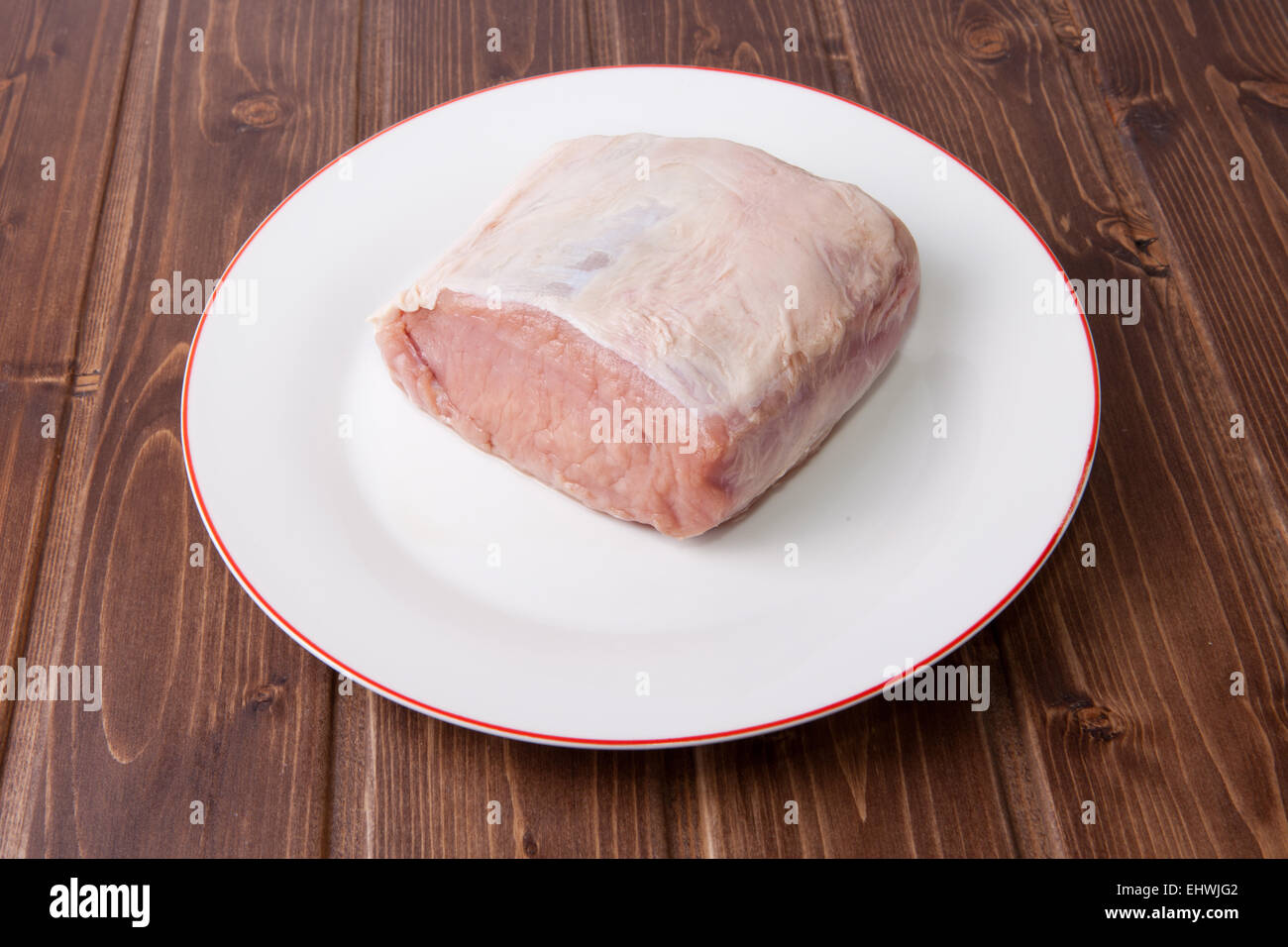 Materie lombo di maiale nella piastra sulla superficie di legno Foto Stock