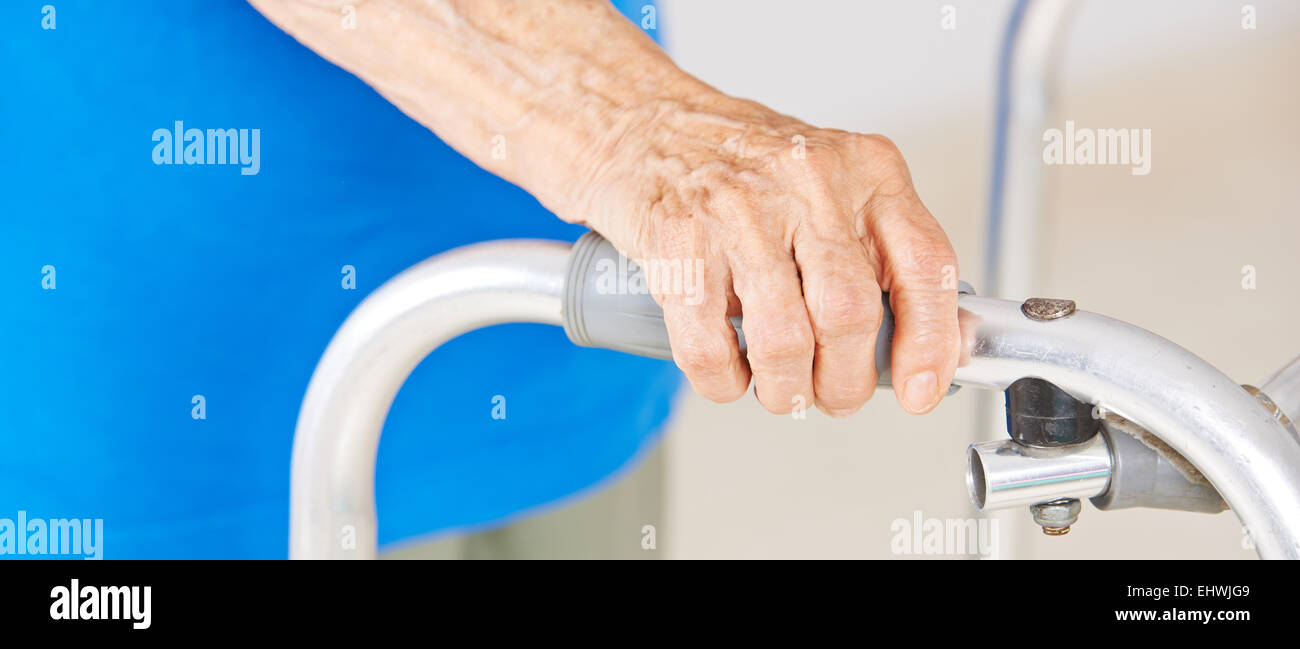 Le mani della donna senior usando un deambulatore per supporto Foto Stock