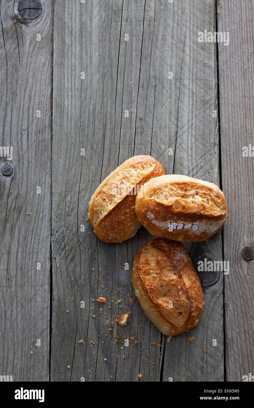 Tre rotoli di pane in legno grigio Foto Stock