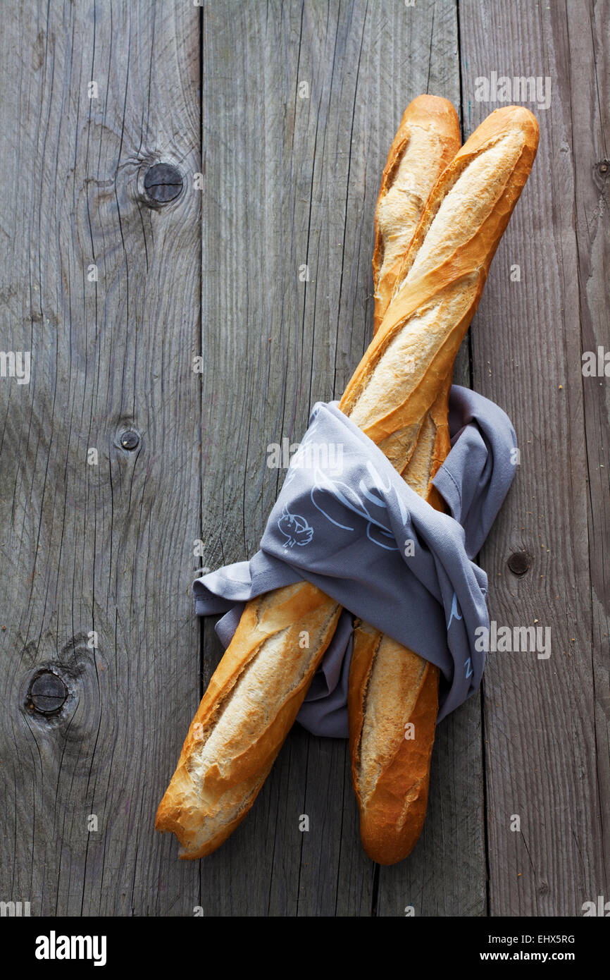 Due baguette francesi e il panno su legno Foto Stock