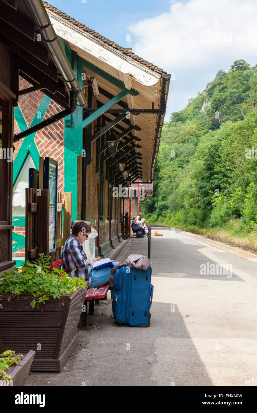 Le persone in attesa di un treno in una zona rurale stazione ferroviaria. Matlock Bath, Derbyshire, England, Regno Unito Foto Stock