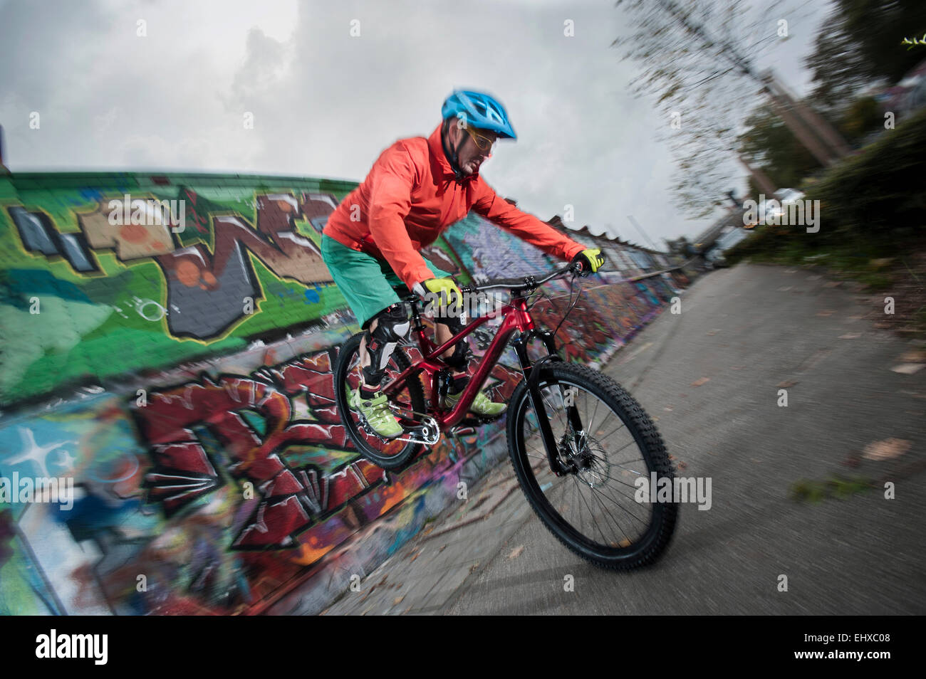 Gli amanti della mountain bike bilanciato sulla ruota anteriore in città, Baviera, Germania Foto Stock