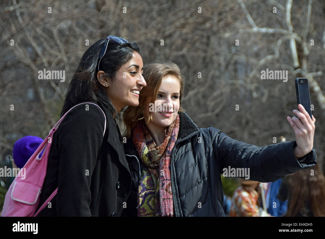 Due belle donne che prendono un selfie vicino alla fontana di Washington Square Park nel Greenwich Village di New York City Foto Stock