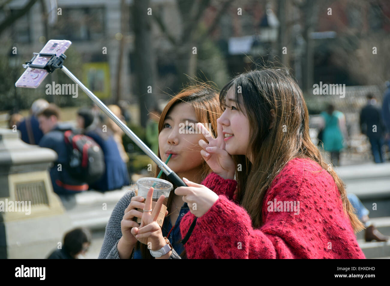 Due donne asiatiche prendendo un selfie vicino alla fontana di Washington Square Park nel Greenwich Village di New York City Foto Stock