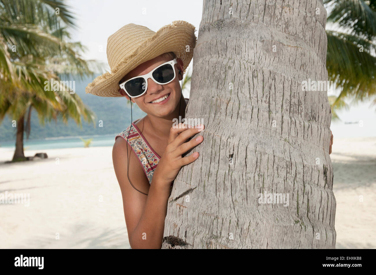 Ragazzo adolescente ascoltare musica sulla spiaggia, Koh Lipe, Thailandia Foto Stock