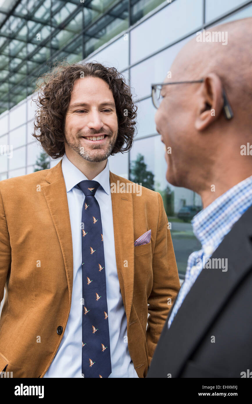 All'esterno gli uomini incontro caucasico africano sorridente Foto Stock