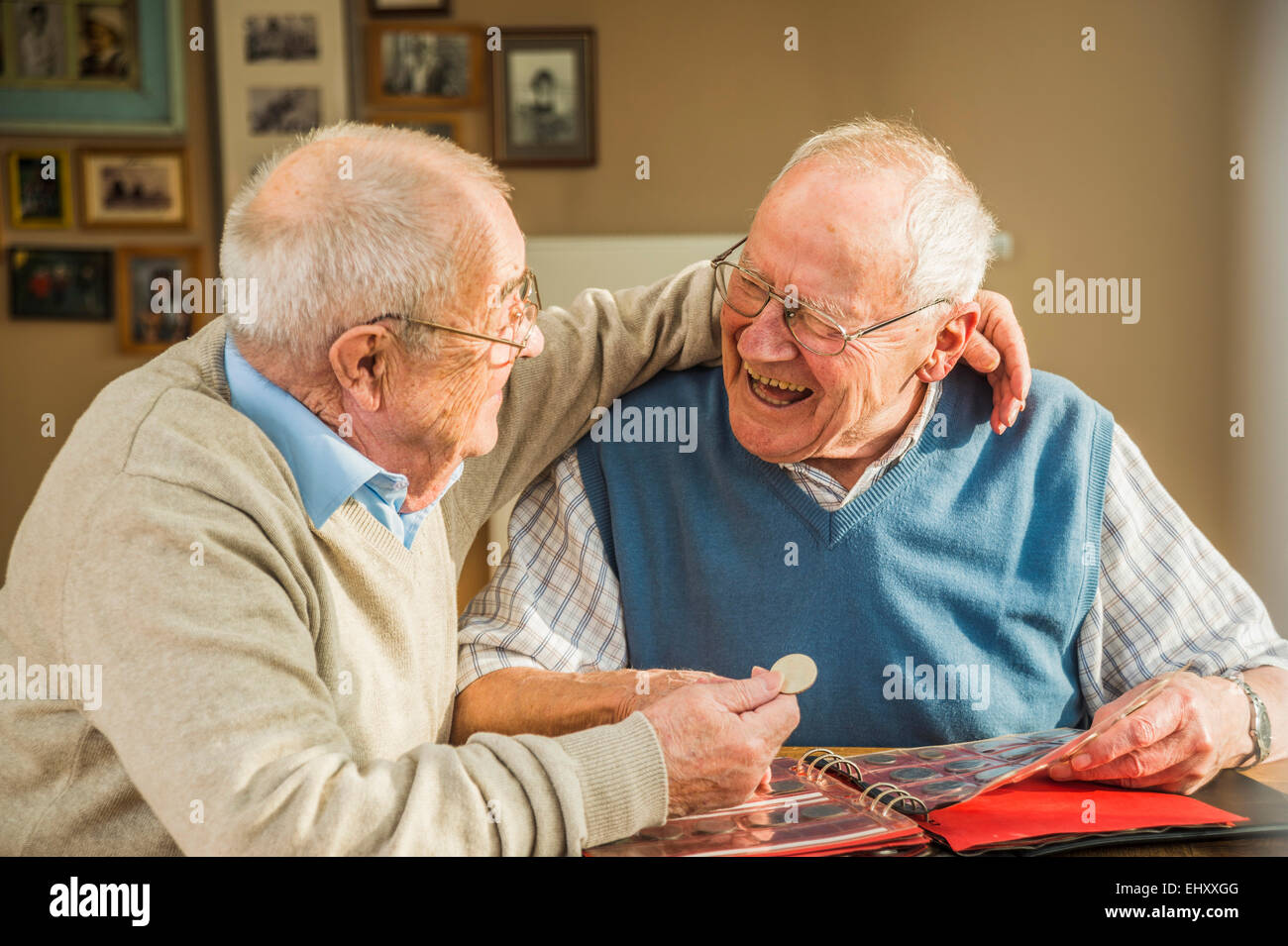 Due felici amici senior con moneta album Foto Stock