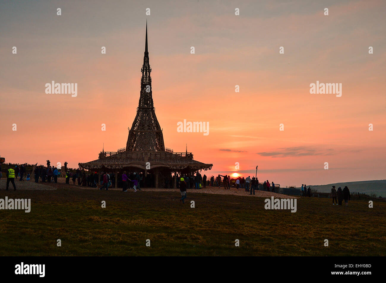 Londonderry, Irlanda del Nord. Il 18 marzo, 2015. Regno Unito meteo. Sunset over Burning Man Tempio. La gente visita il Burning Man tempio in Londonderry al tramonto. Creato da un artista californiano David migliori, il 75 in legno a telaio tempio insieme con cimeli e i messaggi lasciati dalle persone durante questa settimana, sarà bruciato ceremonially sabato marzo 21st. Credito: George Sweeney/Alamy Live News Foto Stock