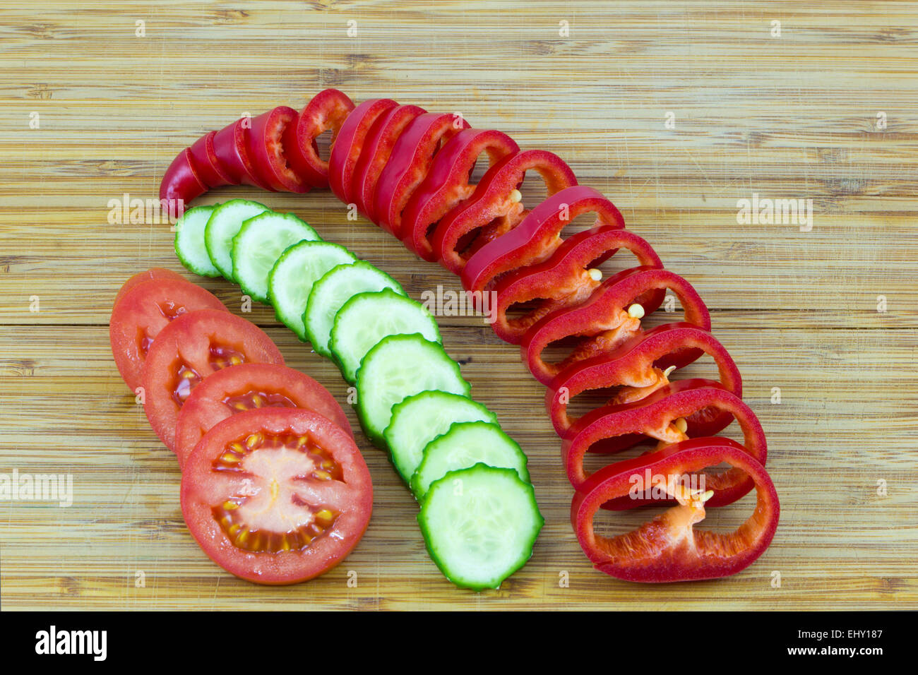 Rosso a fette e verdure verdi su sfondo di legno Foto Stock