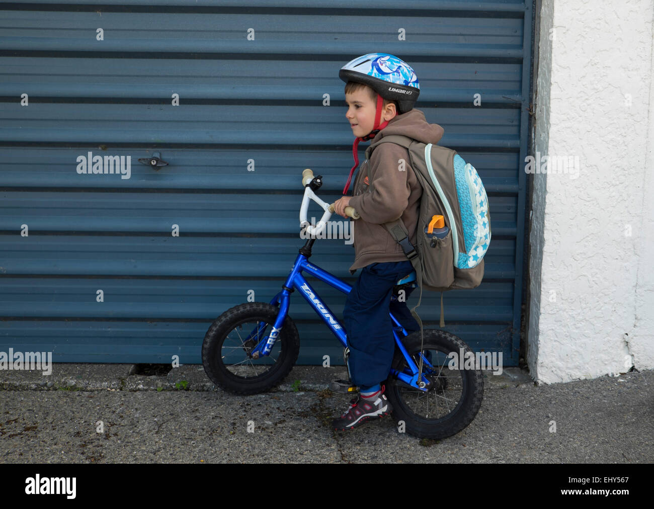Quattro anni di vecchio ragazzo con zaino in bici con casco Foto Stock