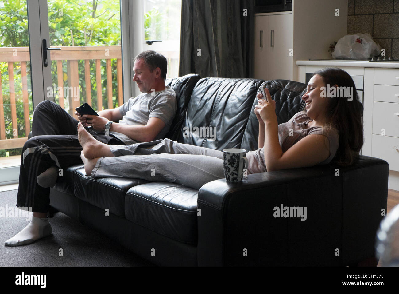 Fratello e Sorella in un momento di relax a casa, sul divano Foto Stock