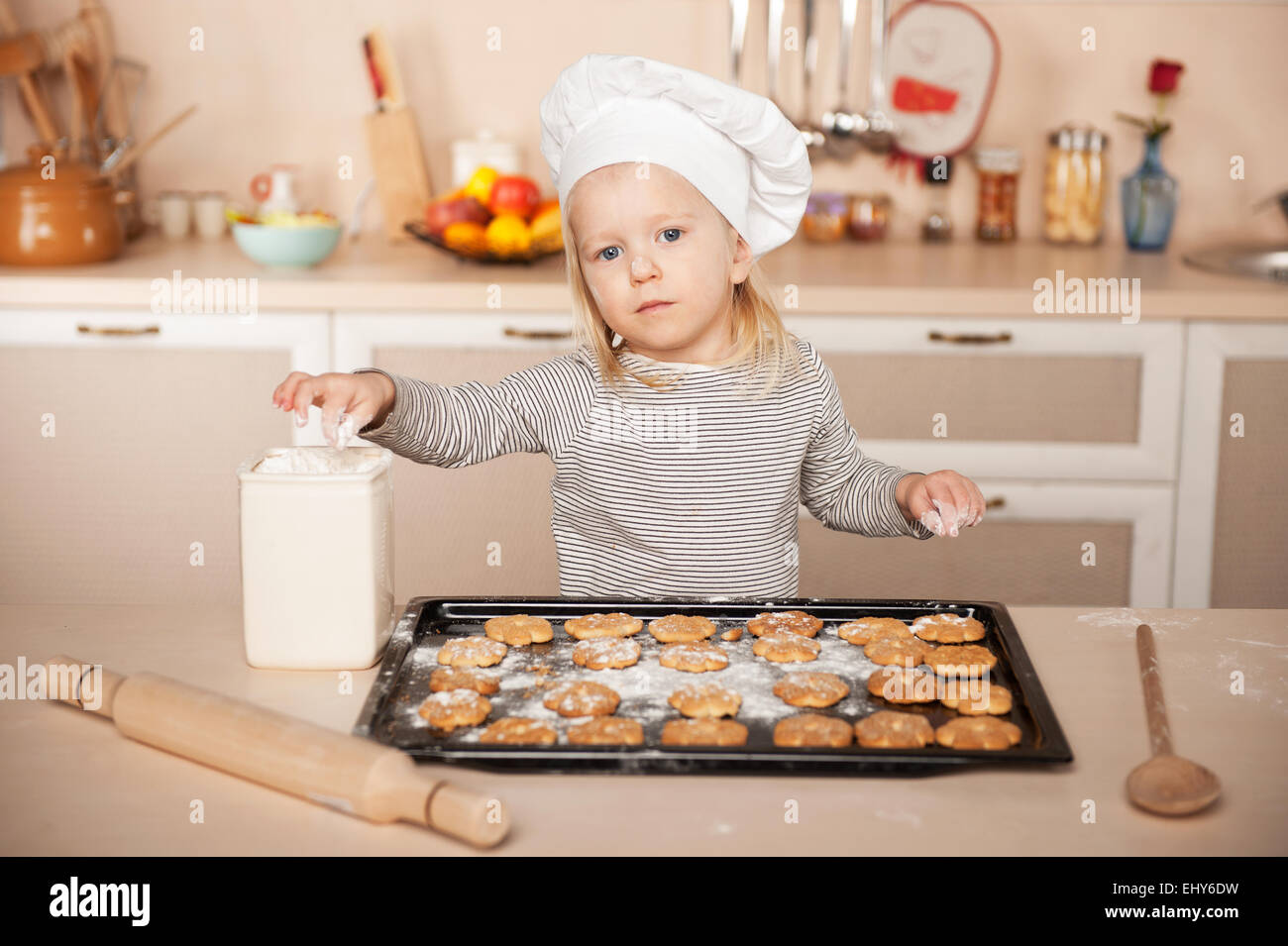 Bambina con chef hat preparare i cookie Foto Stock