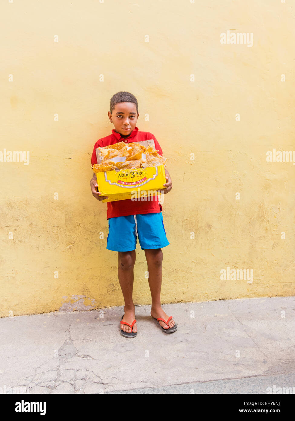 Un giovane ragazzo afro-cubane di vendita di carne di maiale fritto in pelle Havana Vieja. Foto Stock