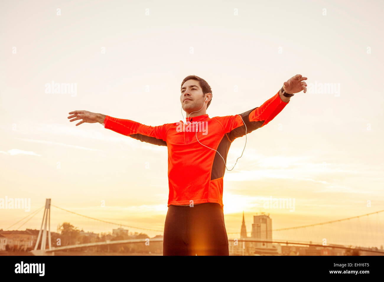 Runner maschio con le cuffie in fase di riscaldamento Foto Stock