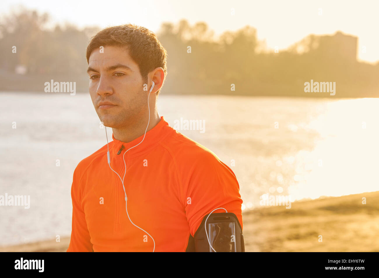 Runner maschio con le cuffie al tramonto Foto Stock