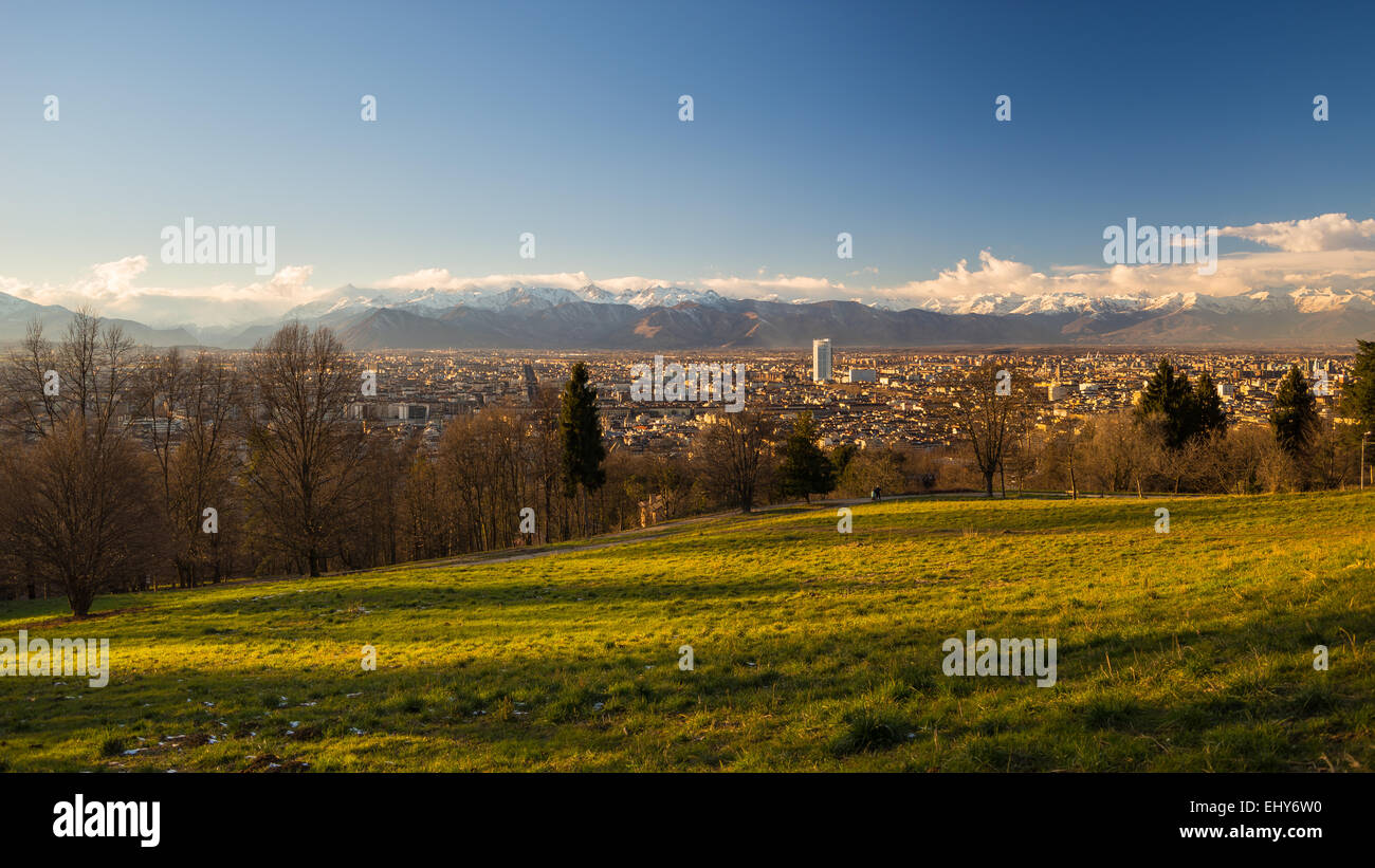 Un punto di vista personale di Torino (Torino), Italia, al tramonto. Vista panoramica dal di sopra con lussureggiante verde prato in primo piano Foto Stock