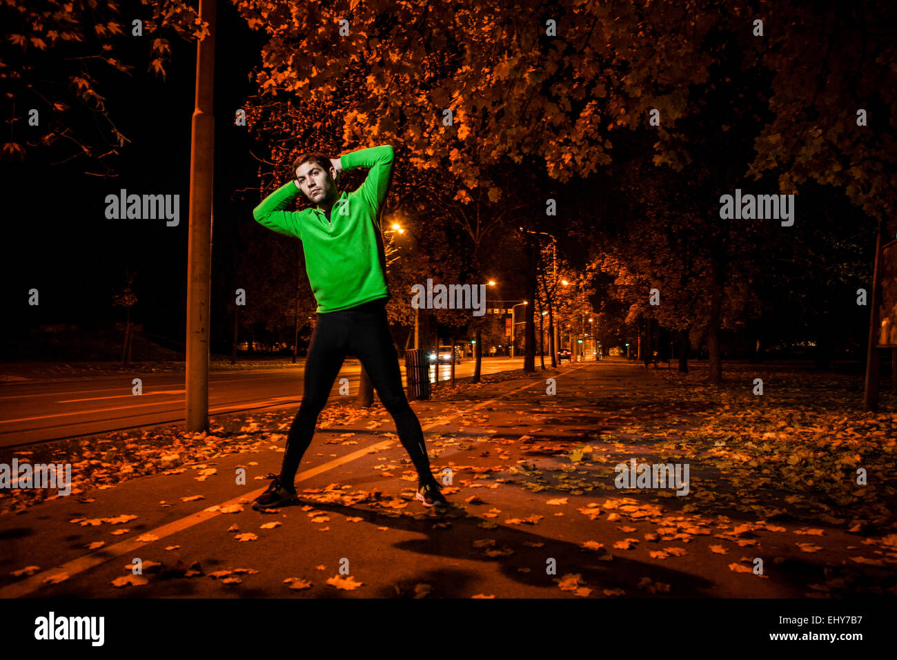 Runner maschio stretching e riscaldamento fino al crepuscolo Foto Stock