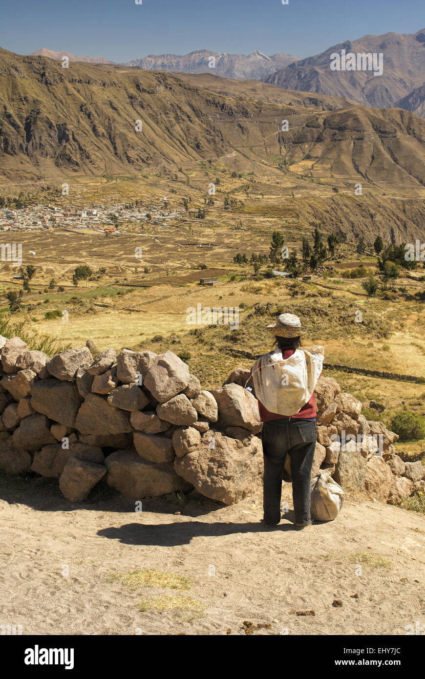 Uomo indigeni guardando arido paesaggio intorno a canon del Colca, famosa destinazione turistica in Perù Foto Stock