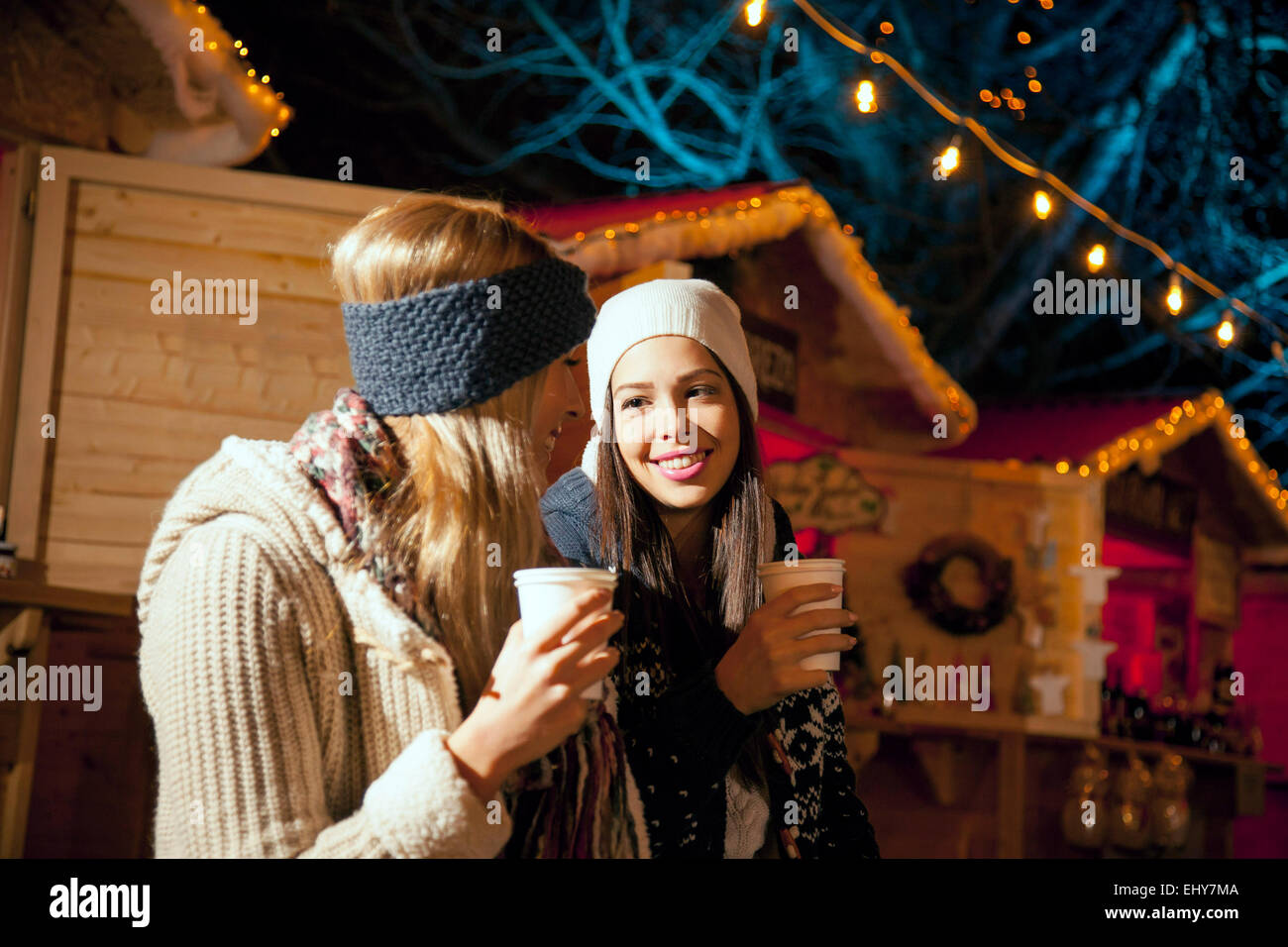 Due donne di bere il punch al mercatino di Natale Foto Stock