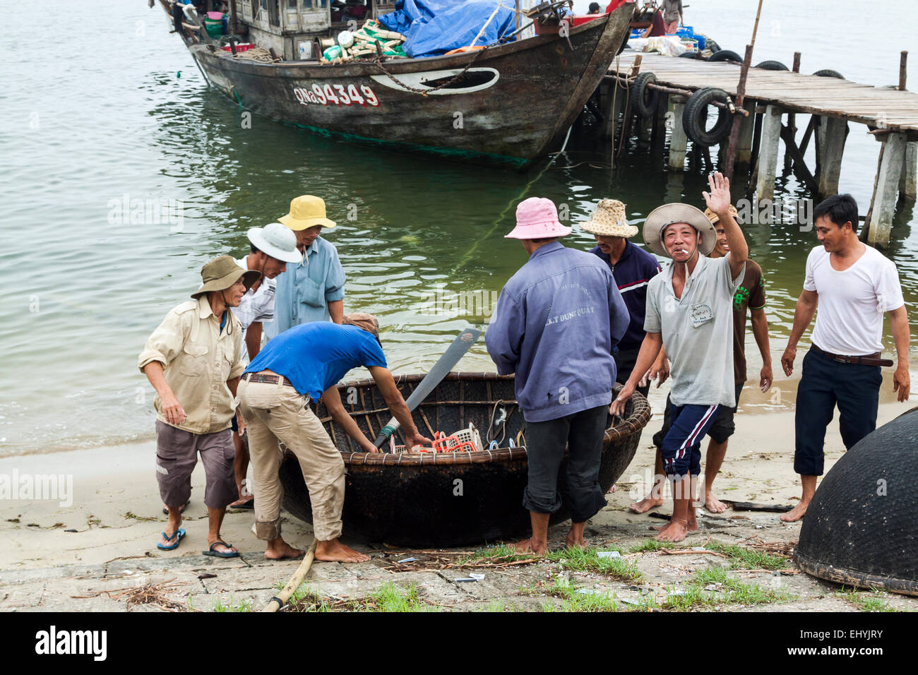 Un intenso commercio di pesci nelle prime ore del mattino nei pressi di Hoi An, Vietnam. Un cestello rotondo-stile barca. Foto Stock