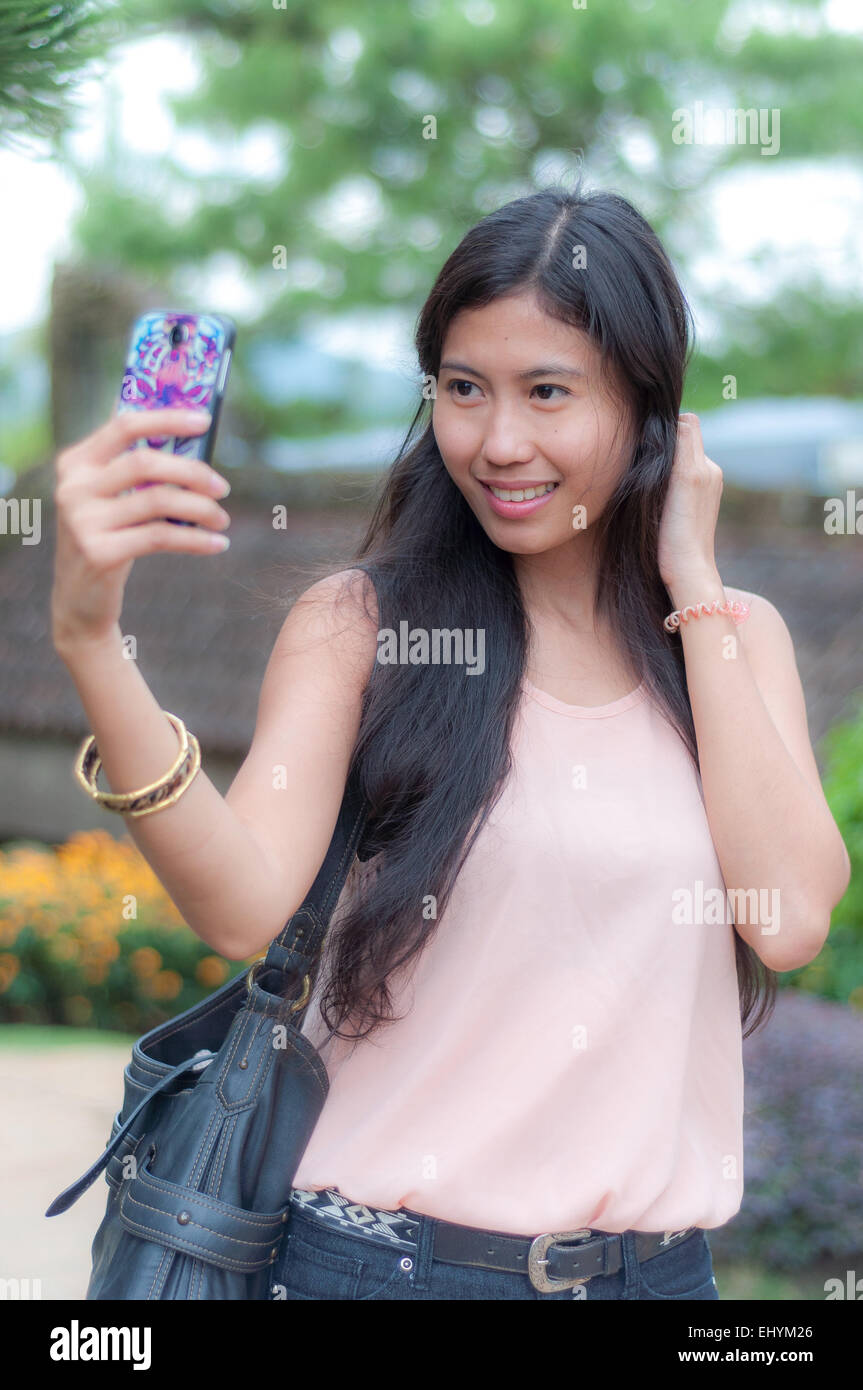 Giovane donna prendendo un selfie Foto Stock