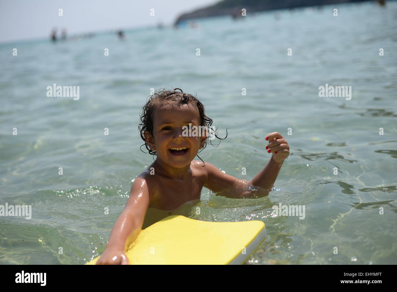 Sorridente ragazza che gioca con un galleggiante in mare, Thassos, Grecia Foto Stock