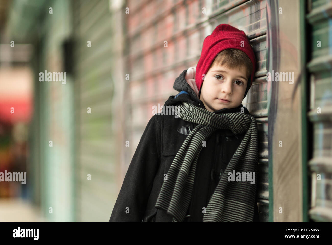 Ragazzo che indossa Red Hat appoggiato contro una parete Foto Stock