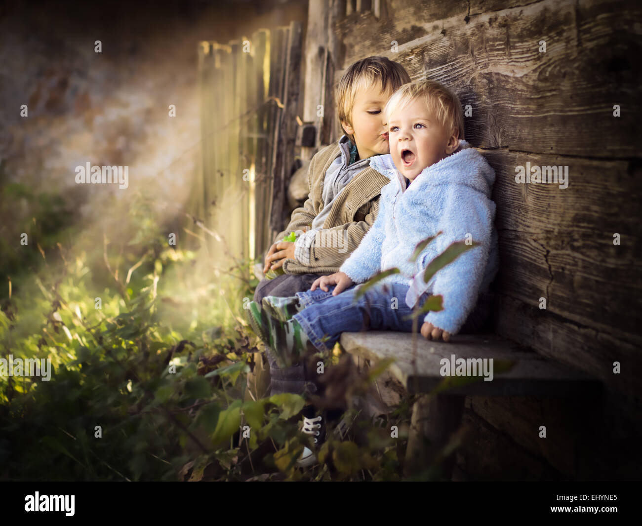 Due fratelli seduto su di una parete avente fun Foto Stock