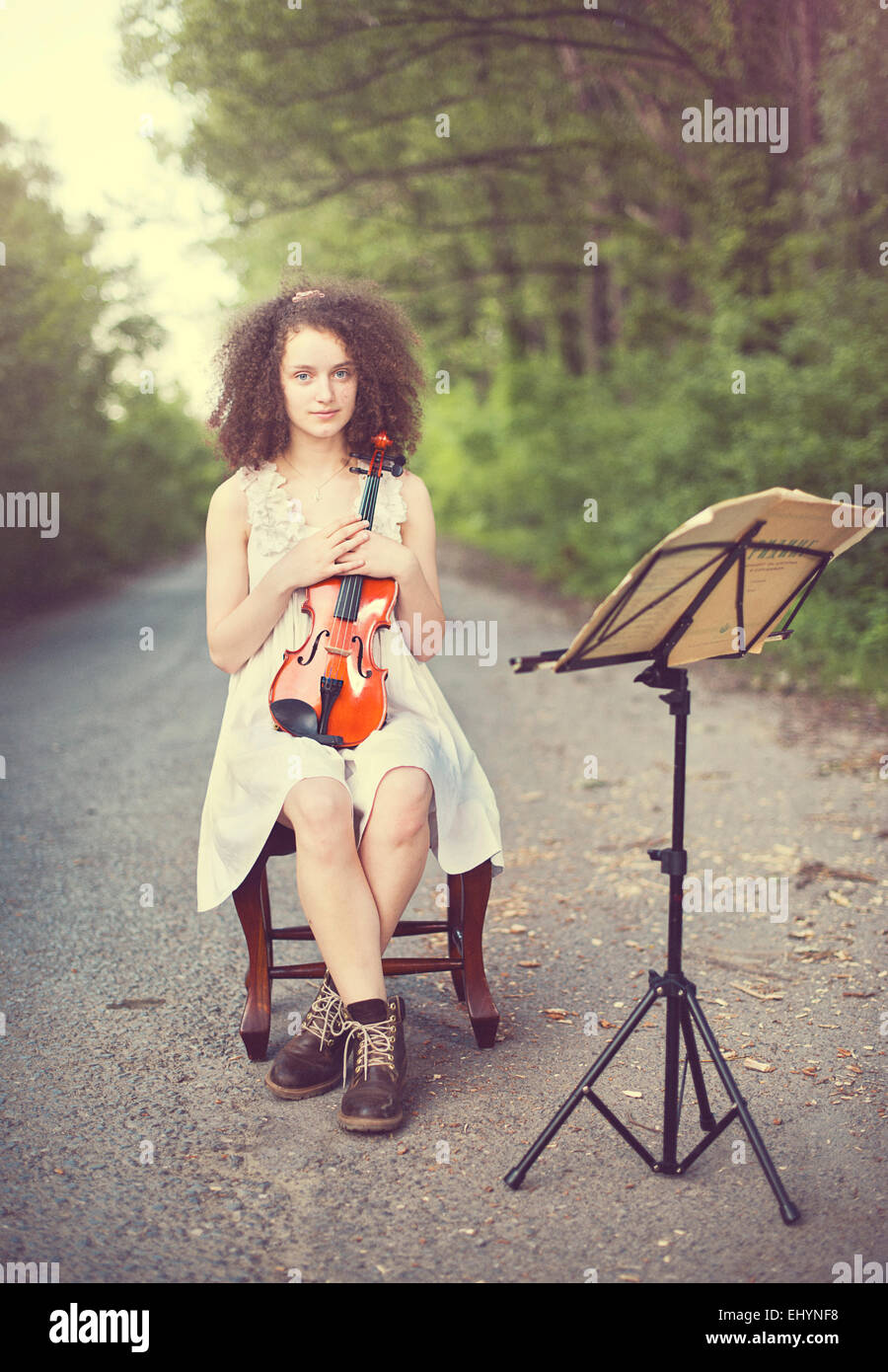 Ritratto di una giovane donna seduta con il suo violino Foto Stock