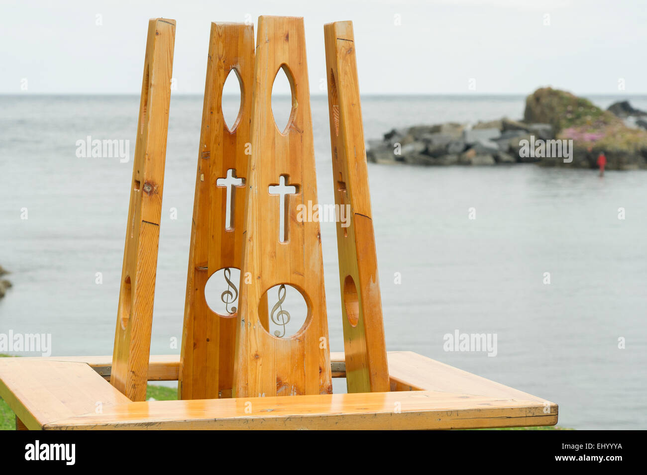 Un ornato panca in legno e si affaccia sul porto di Fair Isle nelle isole Shetland, Scotland, Regno Unito Foto Stock