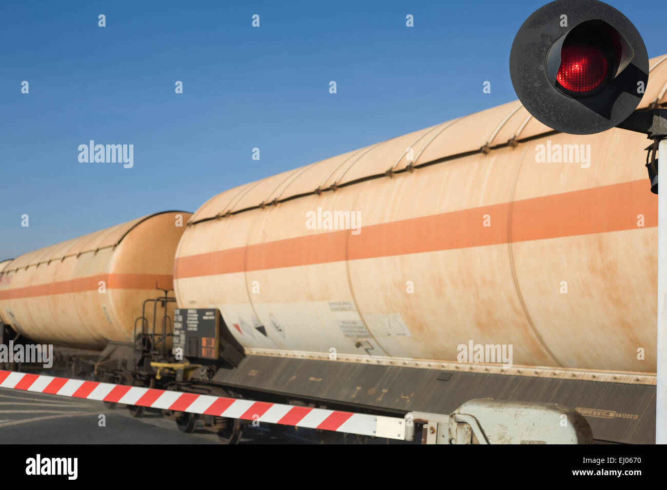 Vagone merci con serbatoi di olio attraversamento su strada Foto Stock