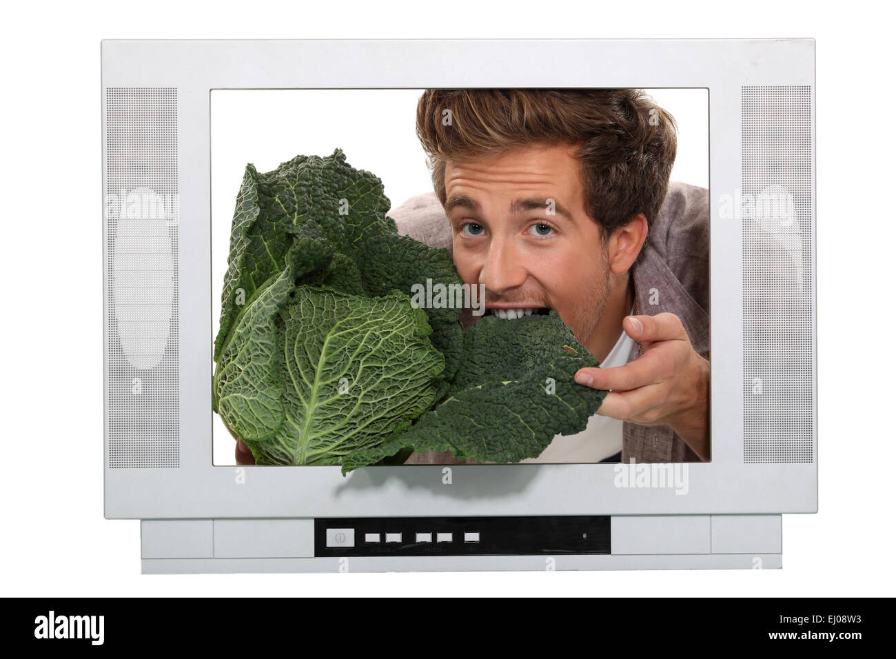Uomo di mangiare un cavolo cappuccio all'interno di un televisore Foto Stock
