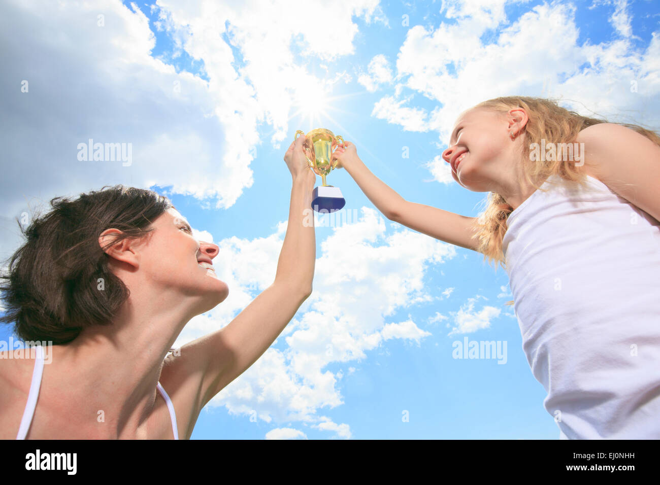 Felice madre e figlia tenendo un trofeo in alto Foto Stock