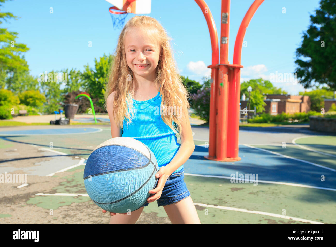 Bambina gioca a pallacanestro con il parco giochi Foto Stock