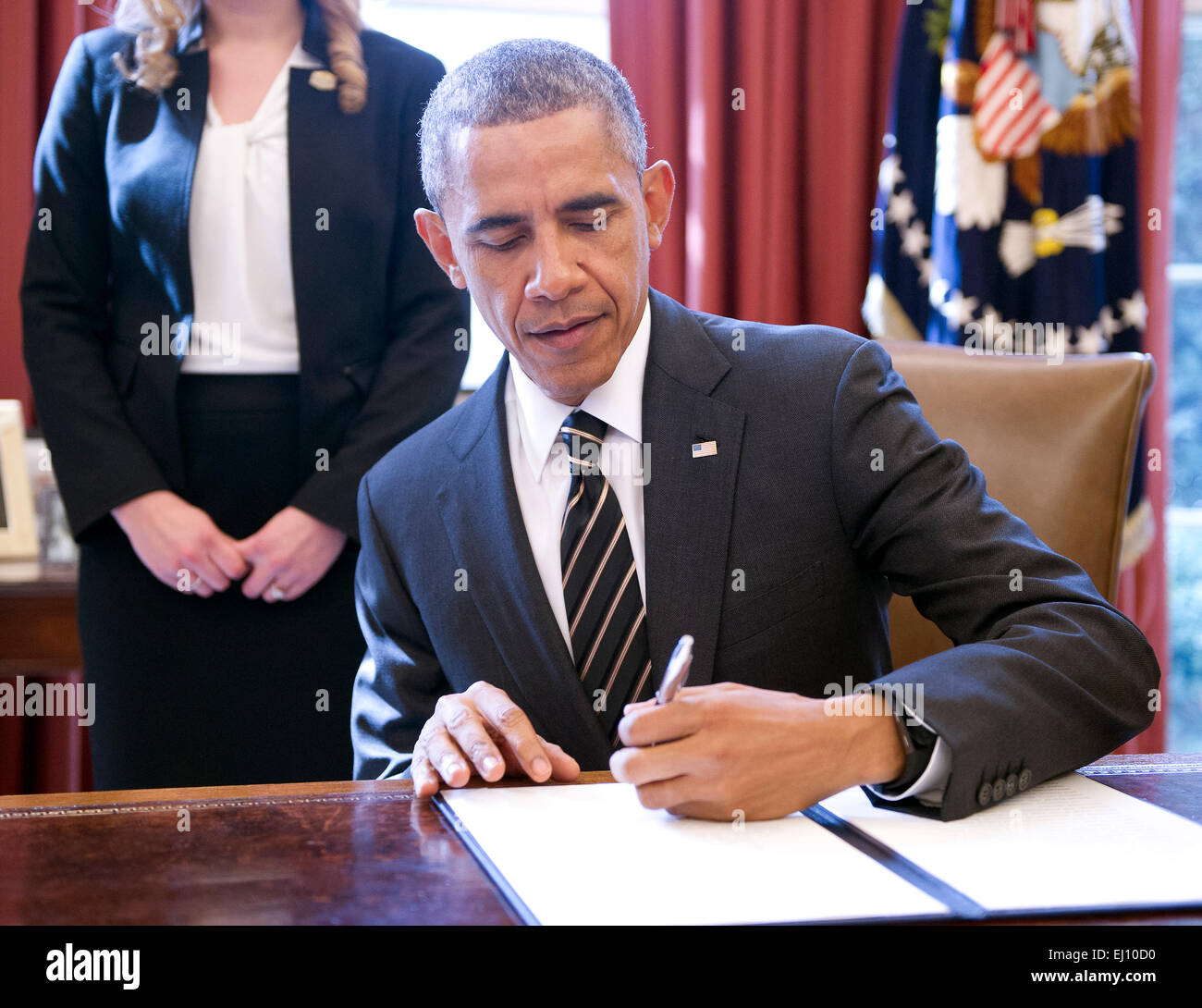 Washington DC, Stati Uniti d'America. Xix marzo, 2015. Il Presidente degli Stati Uniti Barack Obama firma un ordine esecutivo, intitolato 'Pianificazione per la sostenibilità nel prossimo decennio", che permetterà di ridurre il governo federale di emissioni di gas a effetto serra (GHG) 40 per cento nel prossimo decennio dal 2008 livelli, nell'Ufficio Ovale della Casa Bianca di Washington, DC il giovedì 19 marzo, 2015. Foto: Ron Sachs/CNP - nessun filo SERVICE - Credit: dpa picture alliance/Alamy Live News Foto Stock