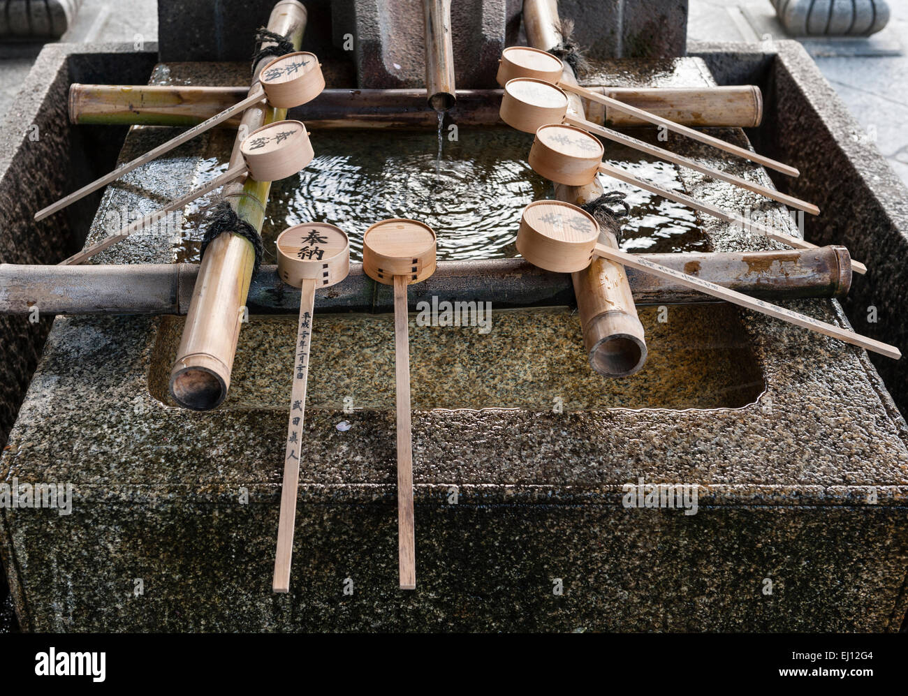 Il temizuya, un fonte di pietra o bacino per la pulizia rituale o l'abluzione al Santuario Yasaka, un tempio shintoista nel quartiere Gion di Kyoto, in Giappone Foto Stock
