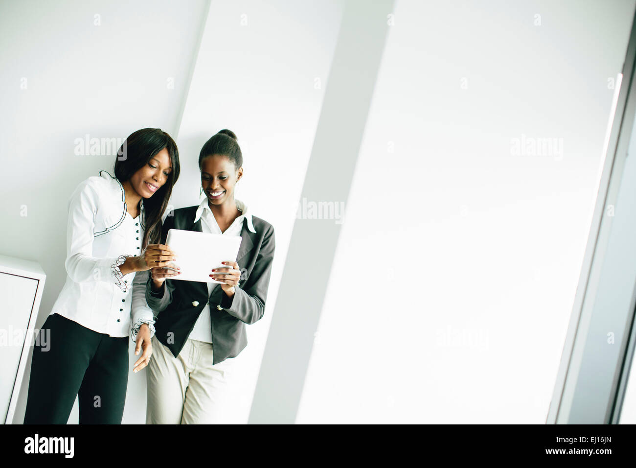 Giovani donne africane con la compressa in ufficio Foto Stock